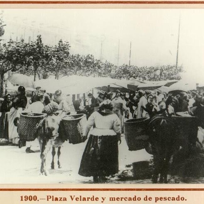 [1900] - Vendedoras de pescado cargan su mercancía en la Plaza Velarde